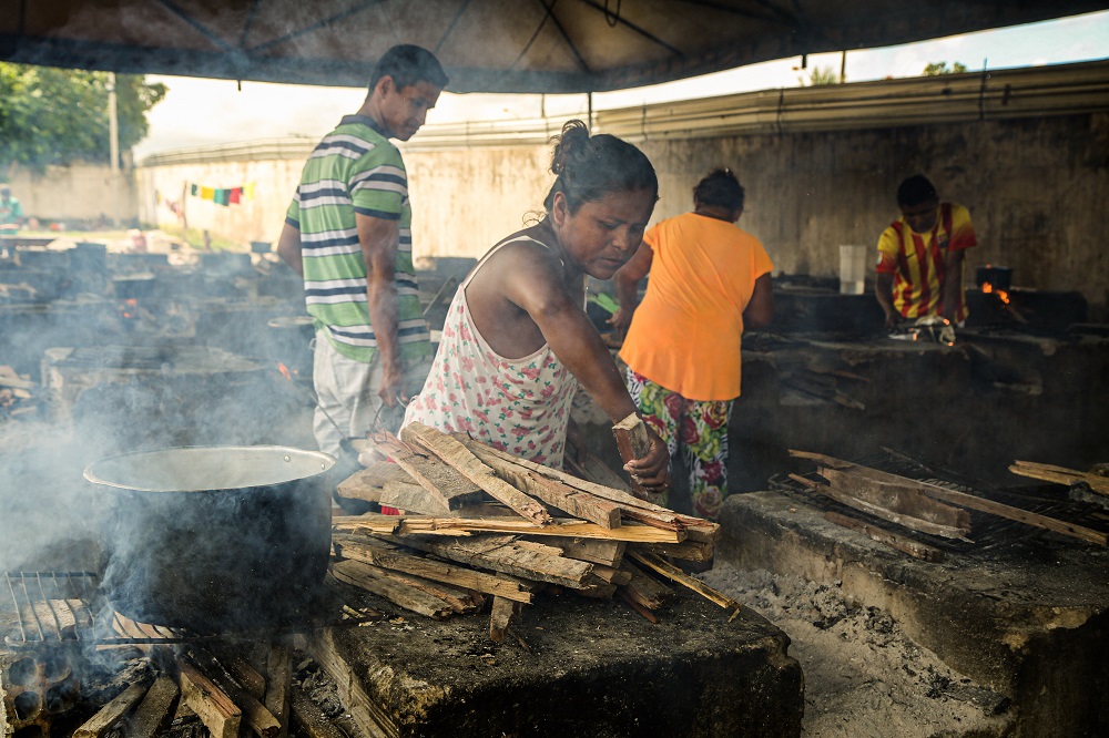 Moradores do abrigo de Pintolândia, em Boa Vista, cozinham com lenha na cozinha coletiva. Os indígenas que vivem lá consideram ser importante cozinhar os próprios alimentos.