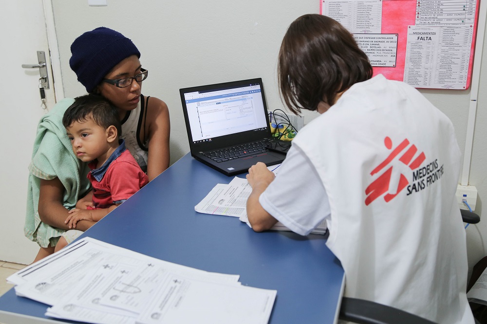 A médica Mariana Valente, de MSF, realiza uma consulta médica com uma criança venezuelana que sofre de pneumonia e conjuntivite, no centro de saúde 13 de Setembro, em Boa Vista.