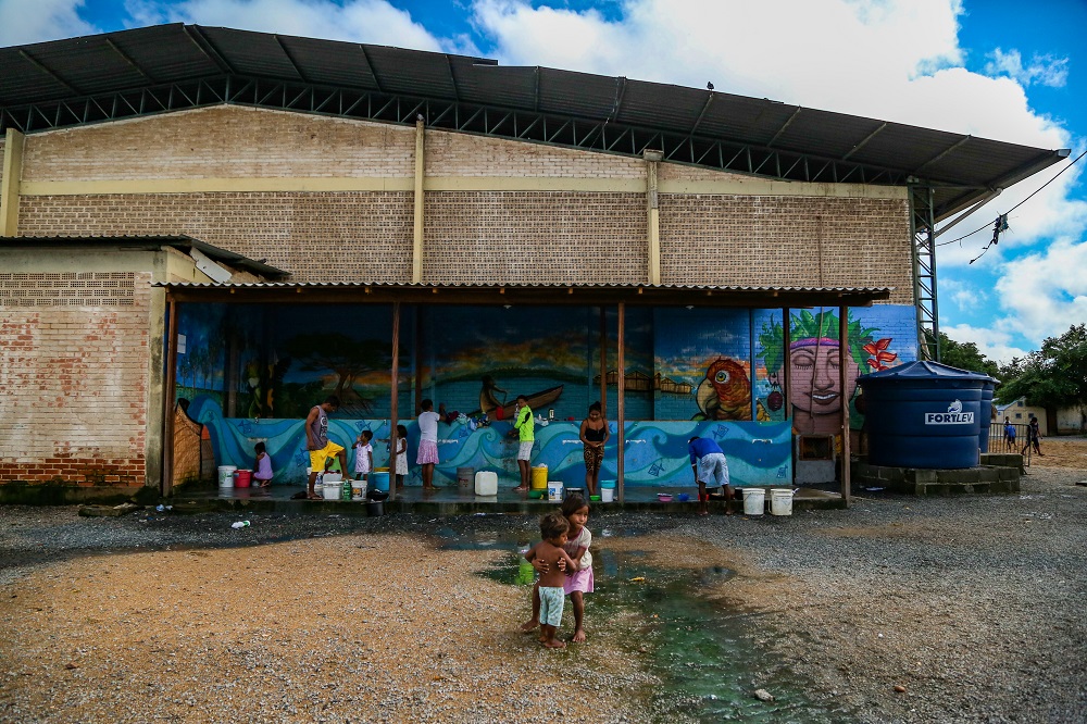 Esgoto a céu aberto perto da área usada para lavar roupa e louça, no abrigo de Pintolândia, em Boa Vista. Mais de 500 indígenas da Venezuela vivem no local.