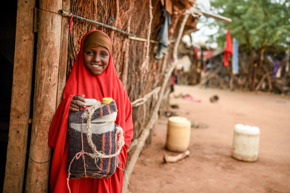 Criança segura seu cooler portátil improvisado após receber seu medicamento no Quênia