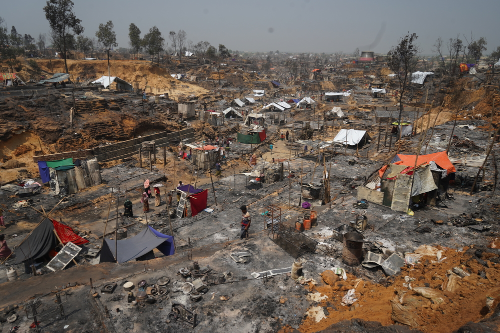 As pessoas começam a reconstruir os abrigos entre os destroços de uma parte do campo para refugiados rohingya no complexo de de Cox's Bazar, que foi destruído pelo fogo. Em março, um grande incêndio deflagrou em Cox's Bazar no Bangladesh, onde vivem cerca de 900 mil pessoas refugiadas.
Bangladesh. Março de 2021.
© Pau Miranda