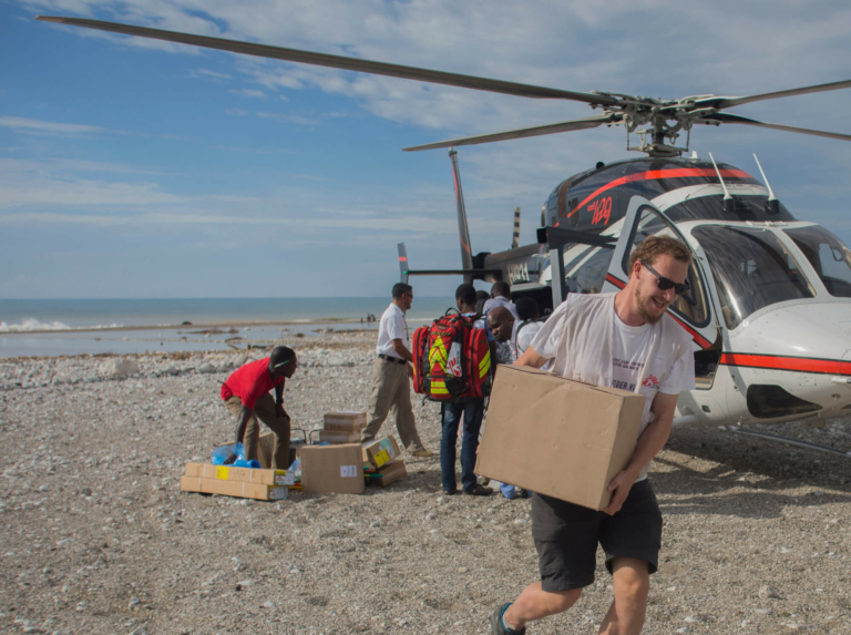 Membro da MSF carrega materiais para clínicas e hospitais em Porto Pimant de um helicóptero vindo de Porto Príncipe.
