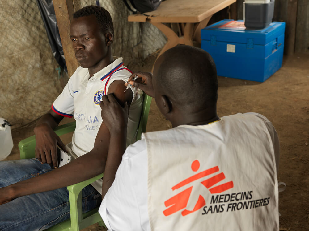 Profissional da MSF vacinando jovem no Sudão do Sul contra Hepatite E.
