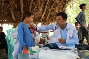 Iftikhar Ahmed escuta uma criança na clínica móvel da aldeia de Miaonlay, em Khyber Pakhtunkhuwa. Paquistão, 12 de setembro de 2022. 