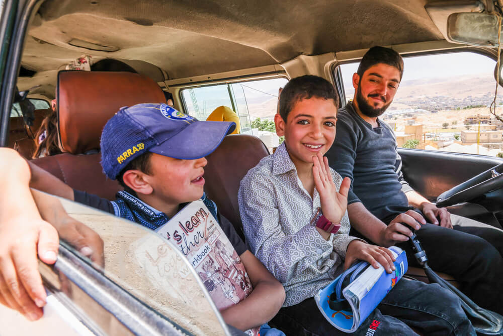Moussa, que vive com diabetes, acena do autocarro a caminho da escola em Arsal, no Líbano.