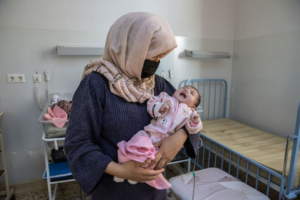 Uma mãe segura a sua bebé Hospital Regional de Mazar-i-Sharif, apoiado pela Médicos Sem Fronteiras no Afeganistão