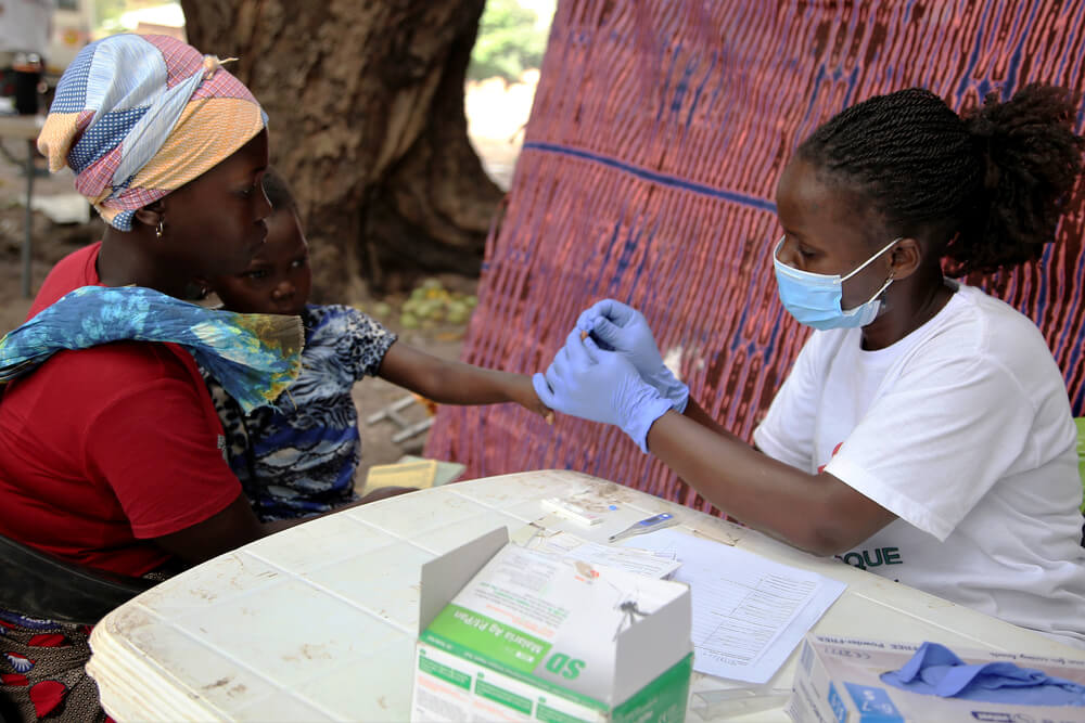 A enfermeira Benvinda examina crianças acompanhadas pela mãe e pela irmã mais velha em uma clínica móvel da MSF na província de Cabo Delgado. Dezembro de 2021.