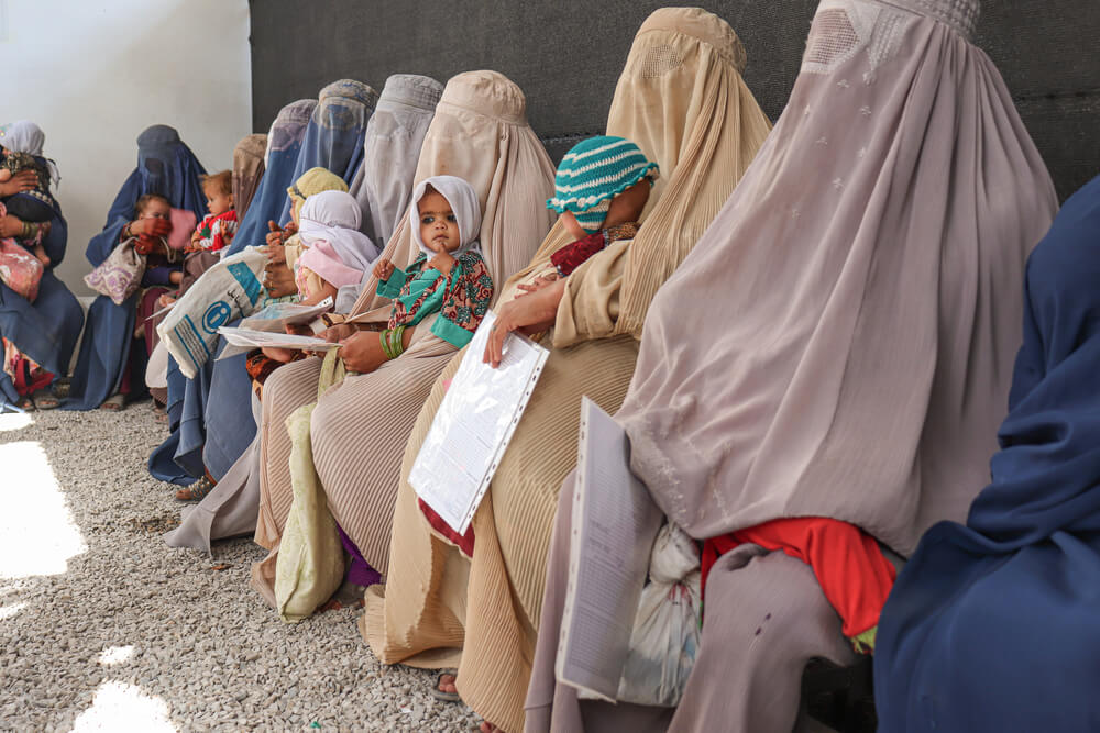 Mulheres sentadas na área de espera do lado de fora do centro de alimentação terapêutica da MSF em Kandahar, no Afeganistão. 