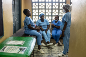 Beatriz*, à esquerda, uma parteira em formação, fala com colegas no centro de saúde de Chingussura, na Beira, onde a MSF apoia a equipa do Ministério da Saúde que presta cuidados de aborto seguro e serviços de maternidade.