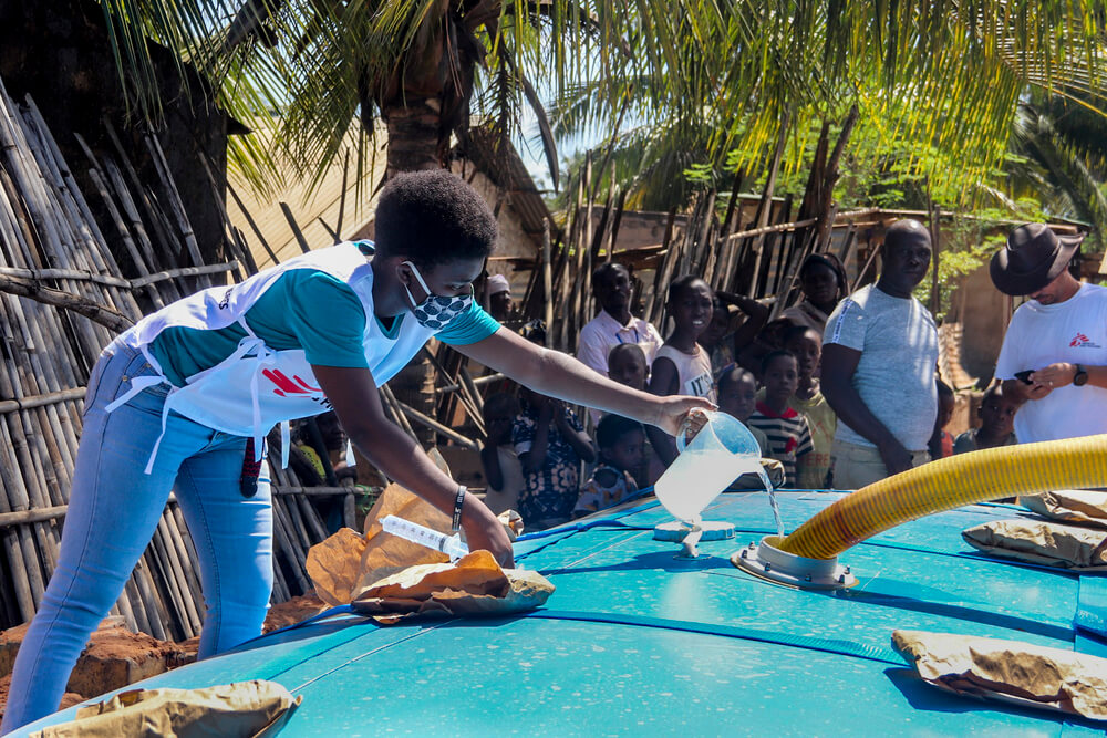 Um membro da equipa da MSF gerencia o tratamento de água em um sítio de distribuição no bairro de Natiti, em Pemba. Abril de 2020. 