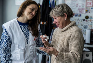 A psicóloga da MSF, Vika, conforta Antonina Sakhnovska, que participa de um grupo de terapia psicológica com outras mulheres na cidade de Pervomaiskyi, em Kharkiv, Ucrânia.