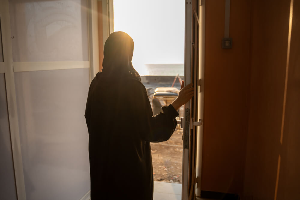 Uma mulher está parada à porta, na maternidade gerida pela Médicos Sem Fronteiras no Hospital Geral de Mocha, no Iémen, enquanto olha para o pôr-do-sol. 