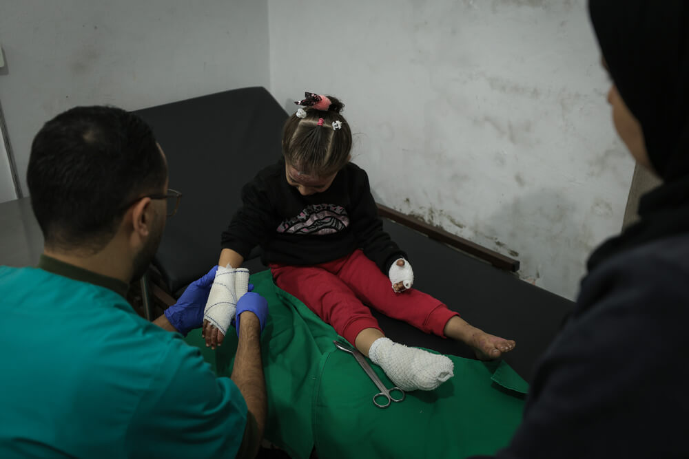 O enfermeiro da MSF, Belal, está a tratar dos pensos de Sham na clínica da da MSF na cidade de Gaza. Depois que casa de Sham foi alvo de ataques, ela sofreu queimaduras e precisou de cuidados médicos. 