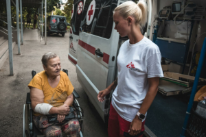 Diana Bilonozhko, trabalhadora MSF, ajuda uma paciente a acomodar-se na ambulância depois de um procedimento de diálise.