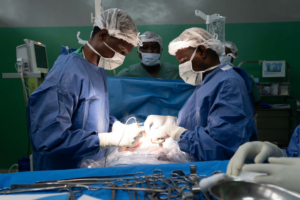 Cirurgiões do Hospital Geral de Referência de Rutshuru, na RDCongo, cauterizam o ferimento de uma jovem vítima de tiro.