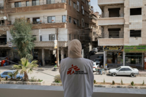 Uma trabalhadora da MSF observa a rua da varanda do Centro de Saúde de Daraya, durante um intervalo.
