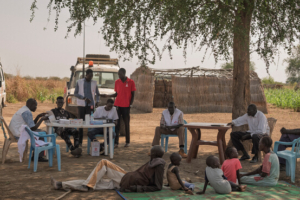 As pessoas reúnem-se à sombra de uma árvore durante uma visita da MSF na aldeia de Makuei Wut, na zona rural de Abyei, no Sudão do Sul.