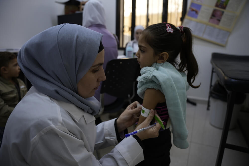 A enfermeira Nawal confere a circunferência do braço de Hanan, de 5 anos, na clínica de Daraya, na zona rural de Damasco.