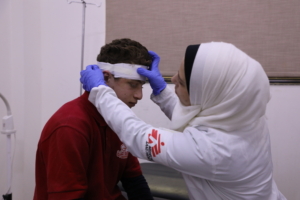 Mohammad Nassar, 17 anos, caiu há alguns dias e bateu com a testa. Esta é a segunda visita para fazer curativos no centro de saúde de Daraya. Na foto, a enfermeira Taghreed está a fazer o curativo na ferida de Nassar.