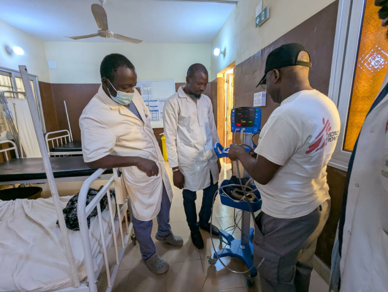 Alexis Seki Mbala, responsável peto setor de enfermagem da MSF, partilha informações sobre a frequência cardíaca de um paciente com os colegas no hospital apoiado pela MSF em Niafunké, no Norte do Mali.