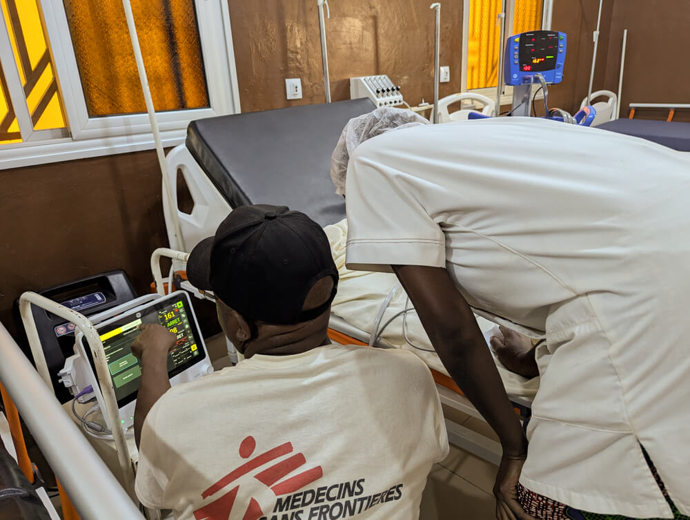 Alexis Seki Mbala, responsável peto setor de enfermagem da MSF, partilha informações sobre a frequência cardíaca de um paciente com os colegas no hospital apoiado pela MSF em Niafunké, no Norte do Mali.