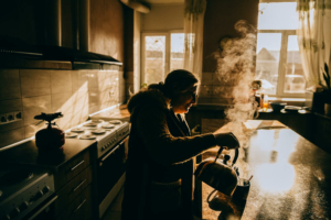 Yuliia Murashkina usa a cozinha no abrigo para pessoas deslocadas em Dnipro, na Ucrânia. A cozinha está banhada pela luz do sol e não há eletricidade.