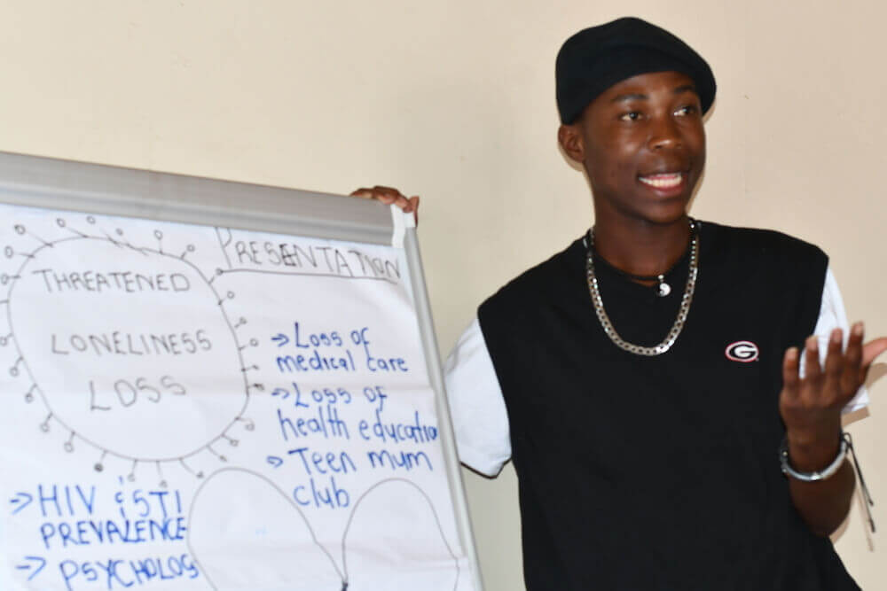 Thormilson Thompson partilha um feedback com os membros da equipa MSF durante uma reunião de revisão e planeamento do Comité de Aconselhamento para Adolescentes.