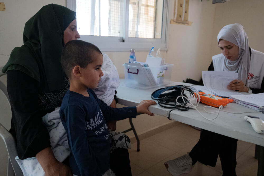 Uma mãe palestiniana recebe atendimento médico na clínica móvel da MSF em Jinba, Masafer Yatta, a Sul de Hebron, na Cisjordânia. 