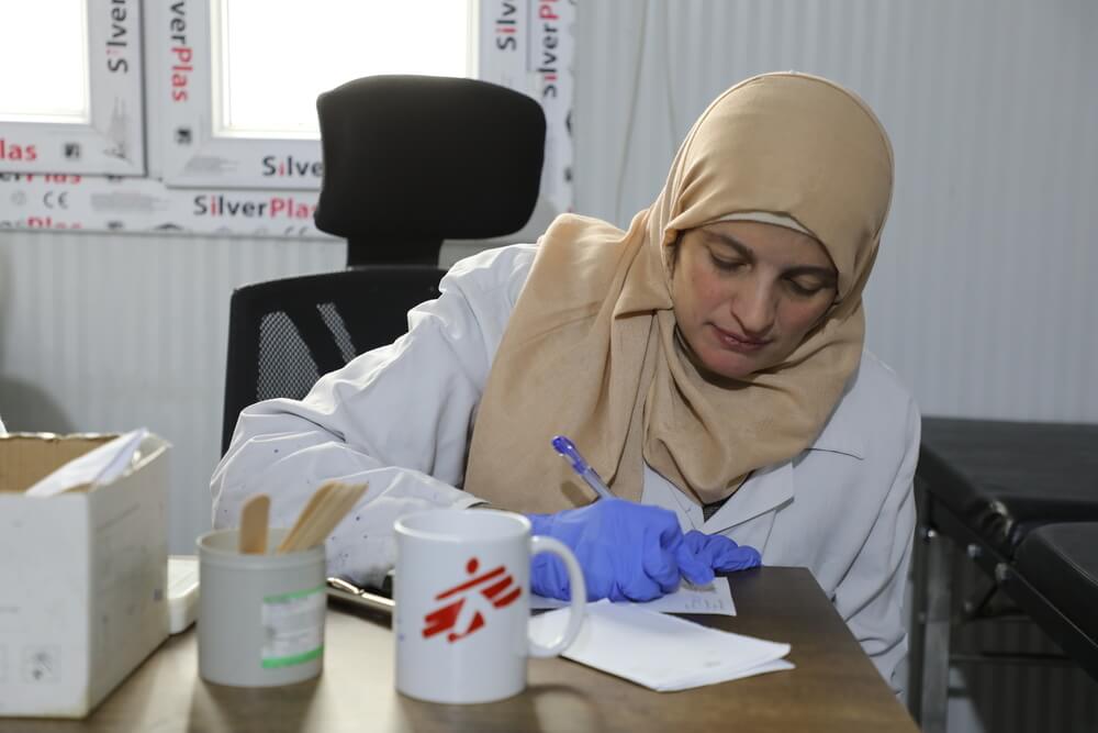 Um pediatra do Centro de Cuidados de Saúde Primários de AL-Khalediyah, na Síria, prescreve uma receita médica para ser entregue na farmácia, que conta com o apoio da MSF.