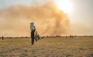 Uma mulher transporta sacos de alimentos na cabeça após um lançamento aéreo realizado pelo WFP perto de Chuil, no estado de Jonglei, no Sudão do Sul.