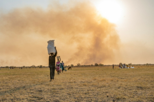 Uma mulher transporta sacos de alimentos na cabeça após um lançamento aéreo realizado pelo WFP perto de Chuil, no estado de Jonglei, no Sudão do Sul.