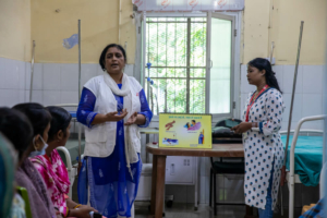 Meena Kumari e Shalini Barla, conselheiras da equipa de apoio aos pacientes, conduzem uma sessão de grupo com cuidadores de pessoas com VIH em fase avançada no hospital Guru Gobind Singh, em Patna, Bihar, Índia.