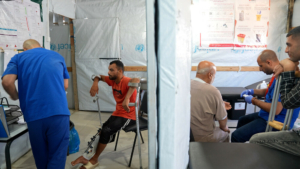 Um membro da equipa de MSF examina a lesão de Saad Hussein, que tem de viver com um fixador externo depois de ter ficado ferido em 2025 durante uma distribuição de alimentos organizada pela GHF.