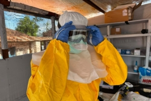 Um membro da equipa de MSF ajusta os óculos de proteção dentro da área de resposta ao Ébola no Hospital Geral de Referência de Mongbwalu, em Ituri, na República Democrática do Congo. Anna SCHÖNHOFER/MSF