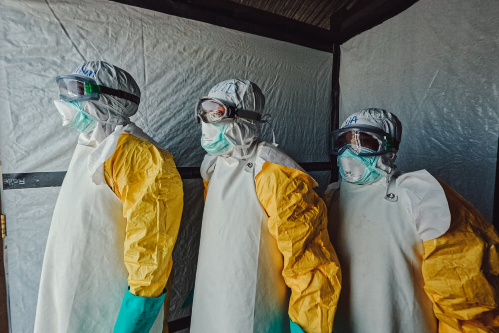 A equipa MSF observa enquanto um caixão sai do Centro de Tratamento do Ébola.