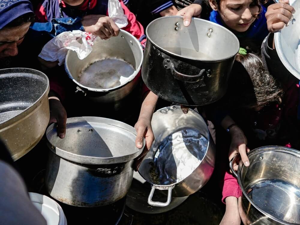 Crianças com as panelas vazias nas mãos numa cozinha comunitária no Norte de Gaza. Fevereiro de 2025. 