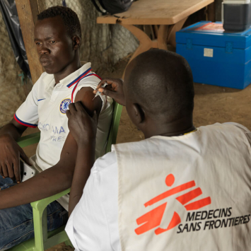 Profissional da MSF vacinando jovem no Sudão do Sul contra Hepatite E.
