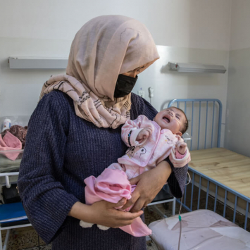 Uma mãe segura a sua bebé Hospital Regional de Mazar-i-Sharif, apoiado pela Médicos Sem Fronteiras no Afeganistão