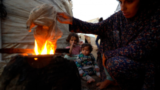 Sem acesso a gás de cozinha, Yasmin é forçada a acender uma fogueira com plástico para preparar uma refeição para os filhos, encontrando formas alternativas de alimentar a família em condições difíceis em Rafah, na Faixa de Gaza.