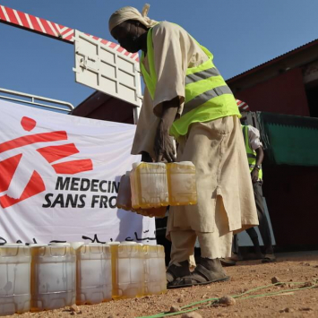 Um trabalhador da MSF descarrega o camião para preparar a distribuição de alimentos nos arredores de Nyala, no Darfur Sul.