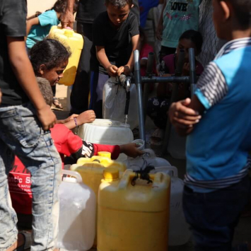 Pessoas tentam obter água em um ponto de distribuição de água da Médicos Sem Fronteiras que funciona ao lado do nosso Centro de Cuidados de Saúde Primários em Mawasi, na Faixa de Gaza.