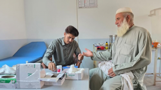 Na unidade de cuidados de saúde primários da MSF no vale de Tirah, Khyber Pakhtunkhwa, um profissional de saúde verifica o nível de açúcar no sangue de um paciente — um exame de rotina que ajuda a prevenir complicações da diabetes em uma região remota.
