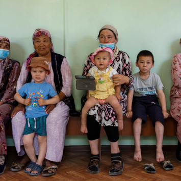 Pacientes sentados em um banco aguardando consulta em Quirguistão