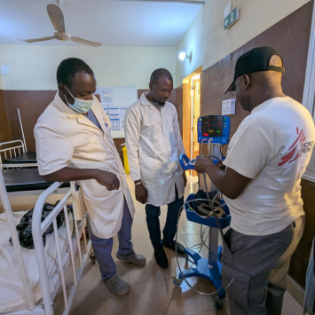 Alexis Seki Mbala, responsável peto setor de enfermagem da MSF, partilha informações sobre a frequência cardíaca de um paciente com os colegas no hospital apoiado pela MSF em Niafunké, no Norte do Mali.