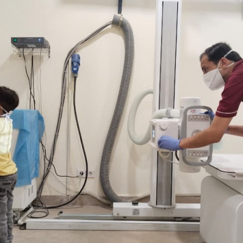 Um técnico de radiologia da MSF faz um exame de raio-X numa criança na clínica de tuberculose da MSF em Karachi, Paquistão. © Gul Nayab