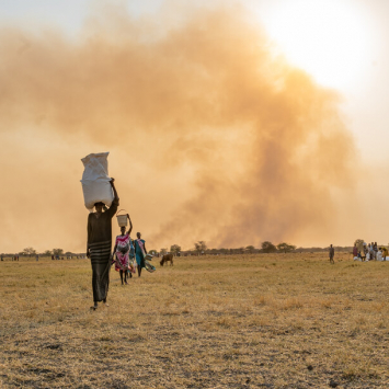 Uma mulher transporta sacos de alimentos na cabeça após um lançamento aéreo realizado pelo WFP perto de Chuil, no estado de Jonglei, no Sudão do Sul.