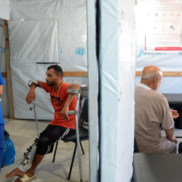 Um membro da equipa de MSF examina a lesão de Saad Hussein, que tem de viver com um fixador externo depois de ter ficado ferido em 2025 durante uma distribuição de alimentos organizada pela GHF.