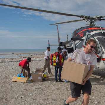 Membro da MSF carrega materiais para clínicas e hospitais em Porto Pimant de um helicóptero vindo de Porto Príncipe.