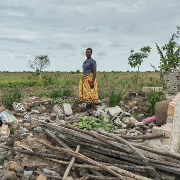 Maria Pedro, que sobreviveu ao ciclone Idai, em pé ao lado do que restou de sua casa