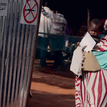 Uma mulher está a caminho da uma clínica de MSF no campo de refugiados de Yida, no norte do Sudão do Sul, para levar seu filho a uma consulta médica. Hoje, são 70 mil refugiados em Yida. A maioria deles são das montanhas de Nuba, no sul do Sudão, de onde eles fugiram dos conflitos. Hoje, MSF oferece assistência médica à população e realizada, em média, 300 consultas por dia. Muitos dos refugiados estão sofrendo com malária e infecções respiratórias por conta das difíceis condições de vida durante a estação chuvosa.       